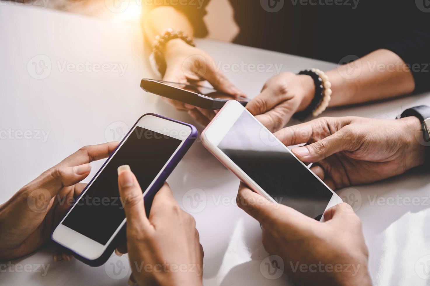 Grupo de jóvenes hipsters sosteniendo el teléfono en las manos en la oficina foto