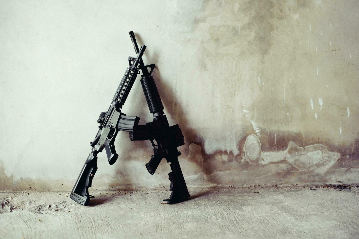 Rifle guns on grunge wall in abandoned house photo