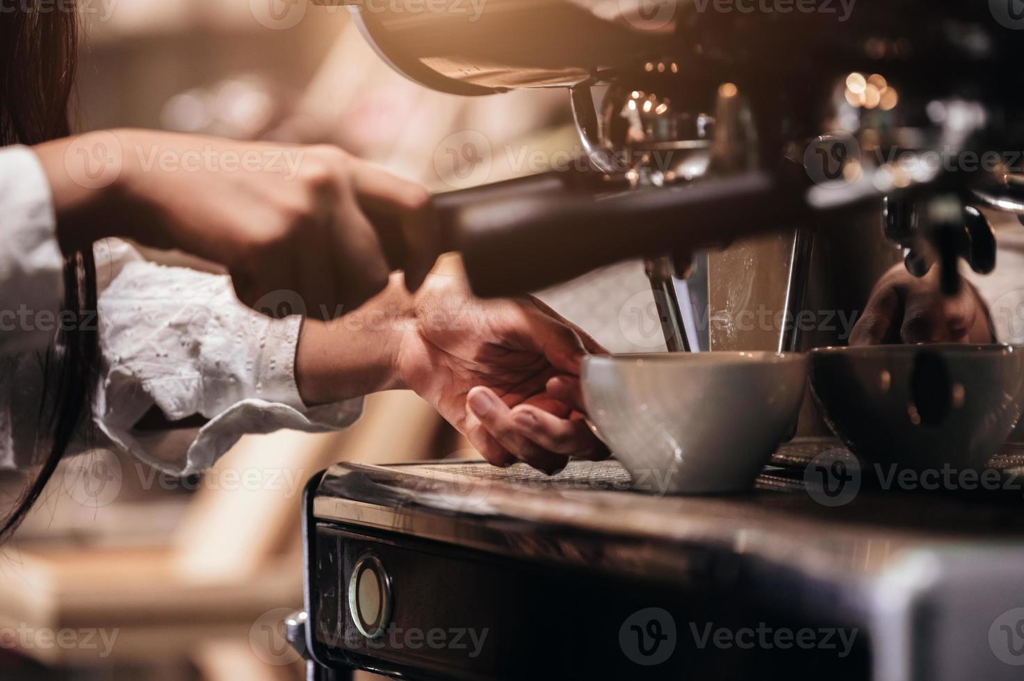 Primer plano de una mujer profesional barista haciendo una taza de café a mano foto