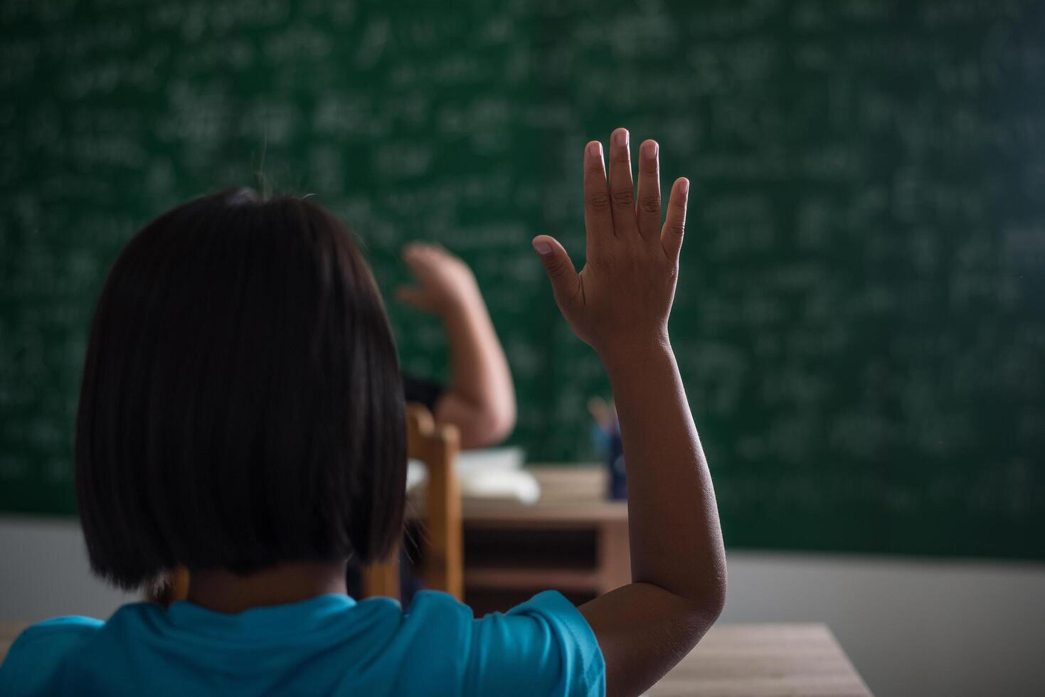 niño levantando la mano en el aula foto