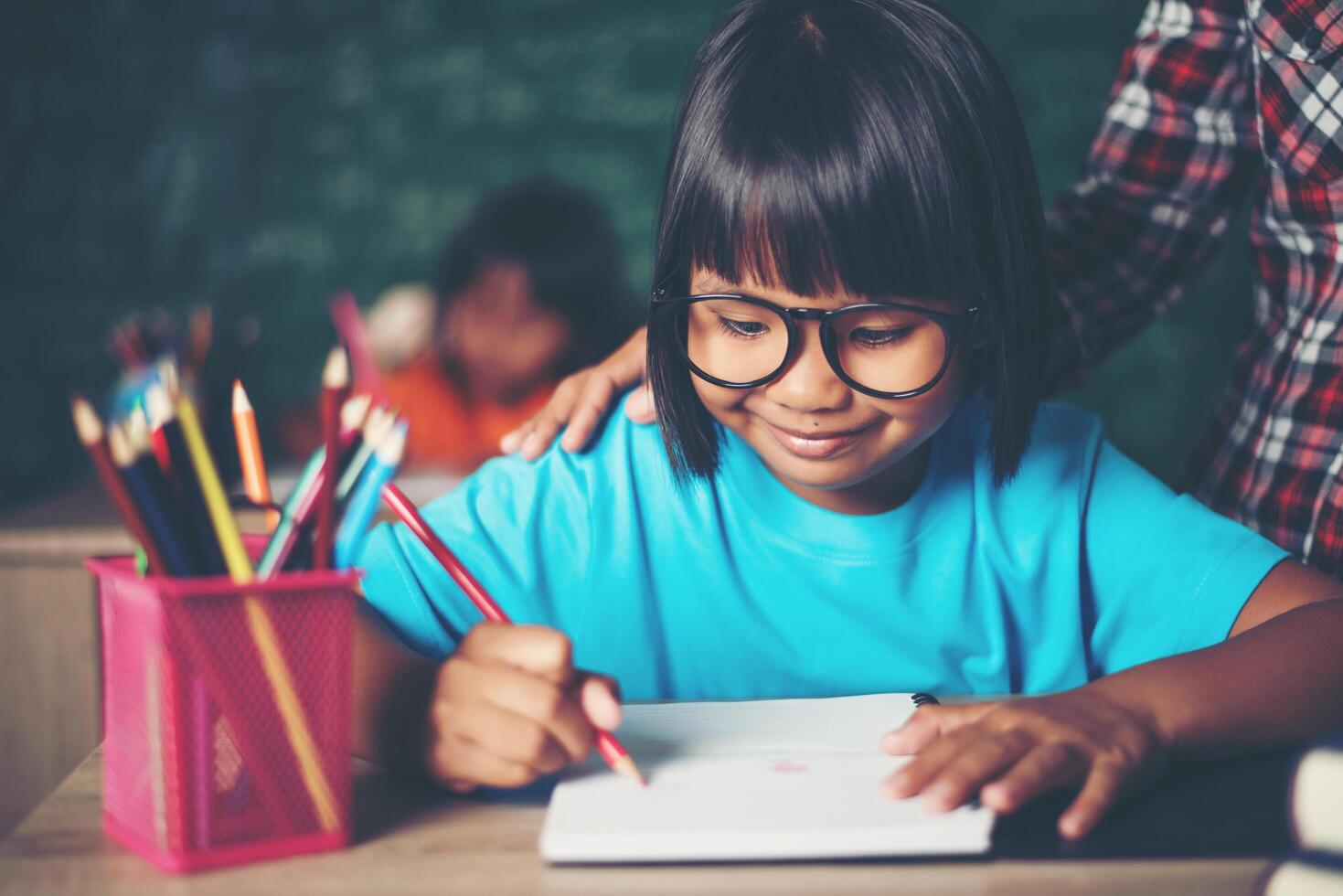 kid  write a book in the classroom. photo