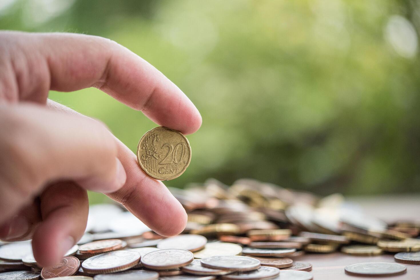 concepto de ahorro de dinero. mano poniendo dinero pila de monedas foto