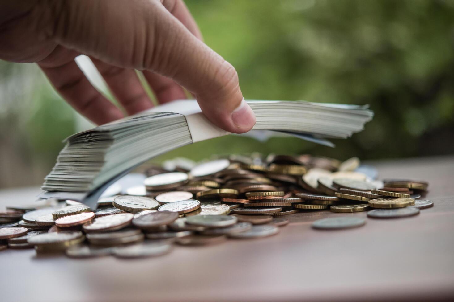 concepto de ahorro de dinero. mano poniendo dinero pila de monedas foto