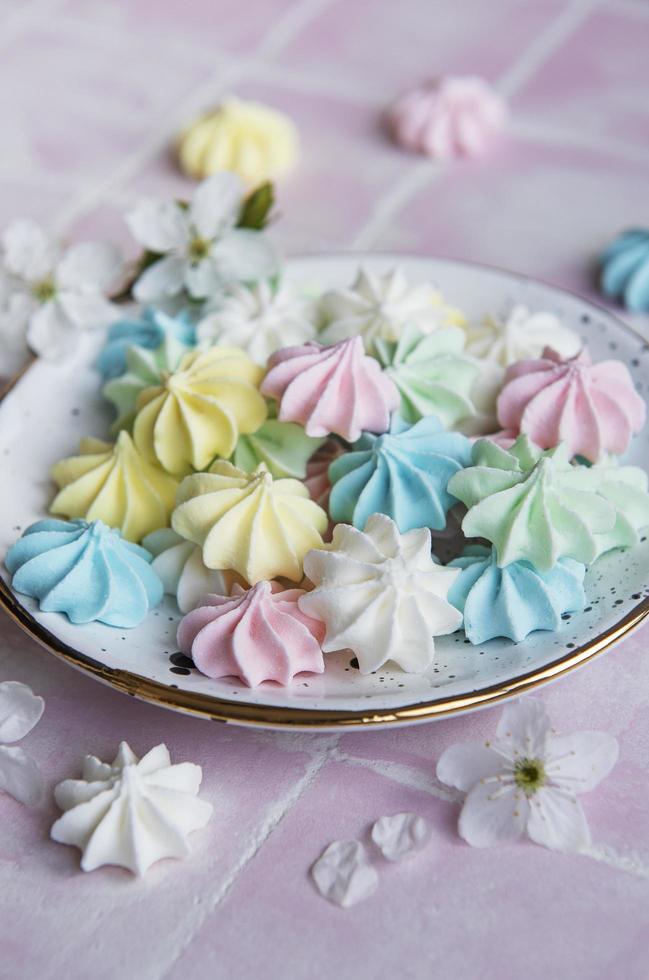 pequeños merengues de colores en el plato de cerámica foto