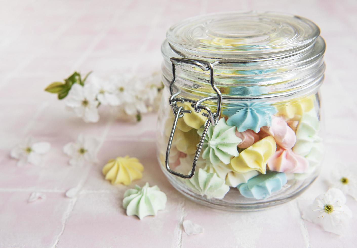 Small colorful meringues in the glass jar photo