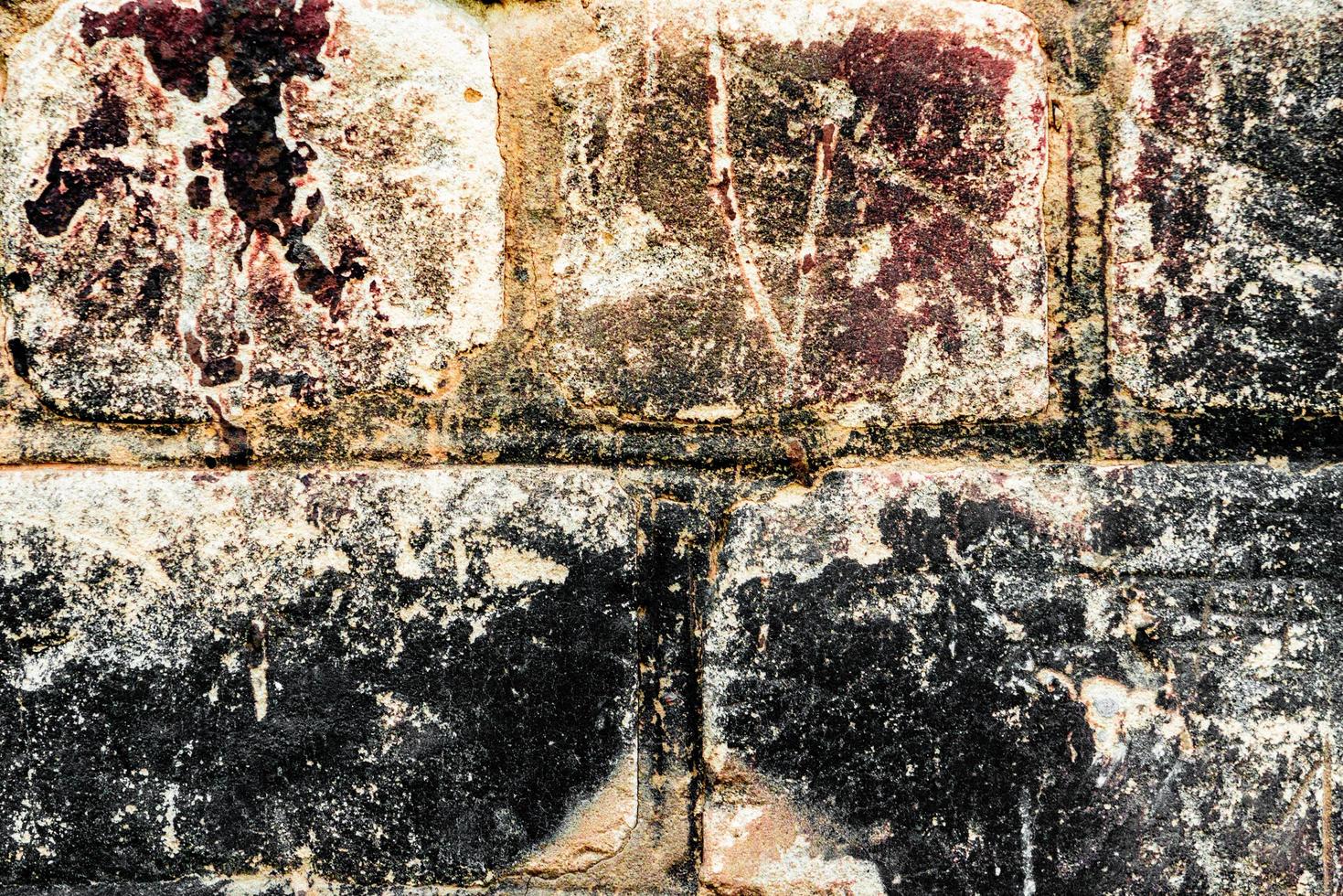 Textura de una pared de ladrillos con grietas y arañazos foto