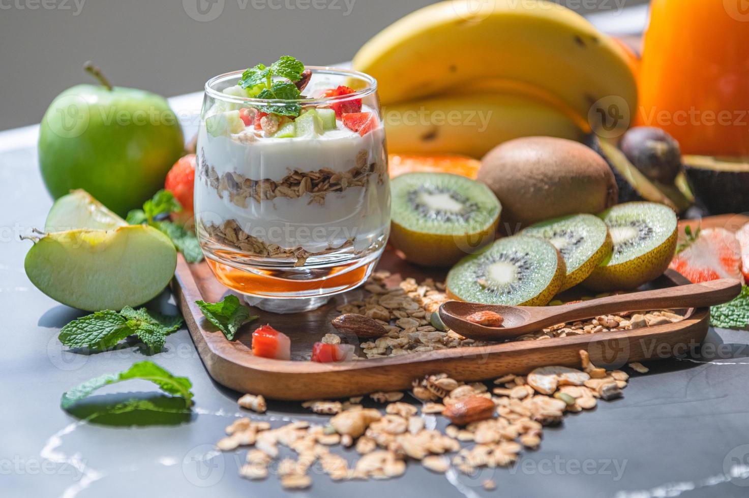 Primer plano de yogur de nutrición con muchas frutas en la mesa foto