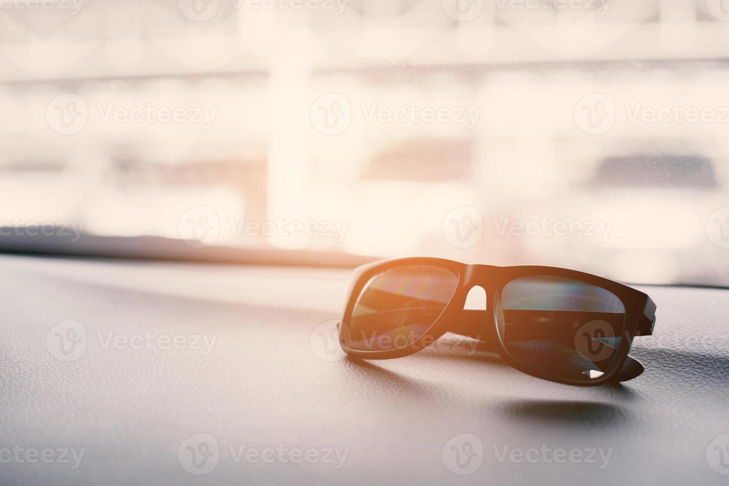 Black sunglasses on the front console of car on traveling photo