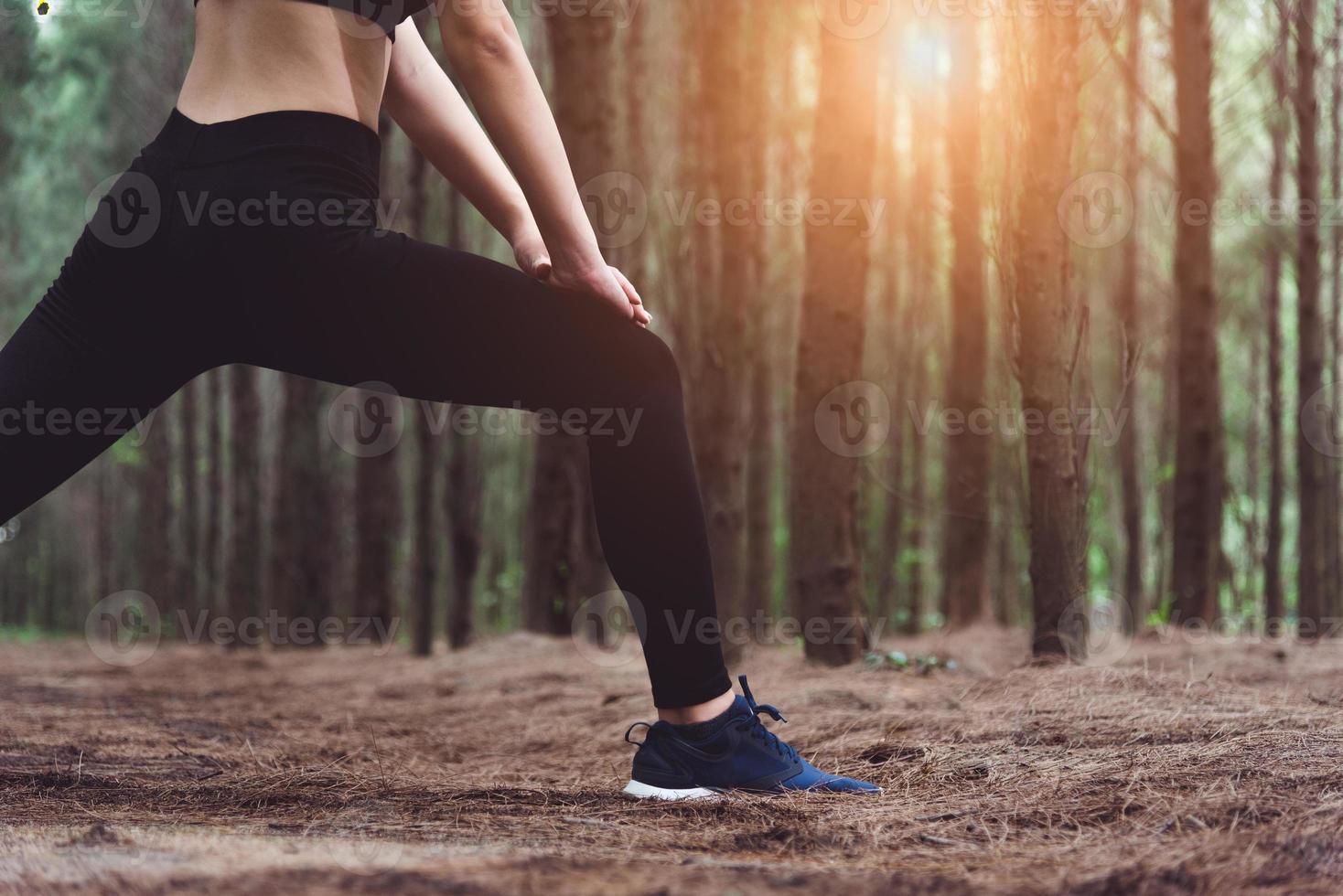 Cerca de la parte inferior del cuerpo de una mujer haciendo yoga y estirando las piernas foto