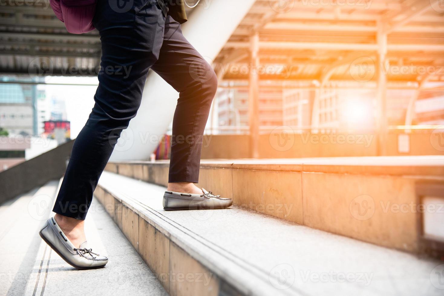 Cerca de las piernas de la mujer subiendo escaleras en la ciudad foto