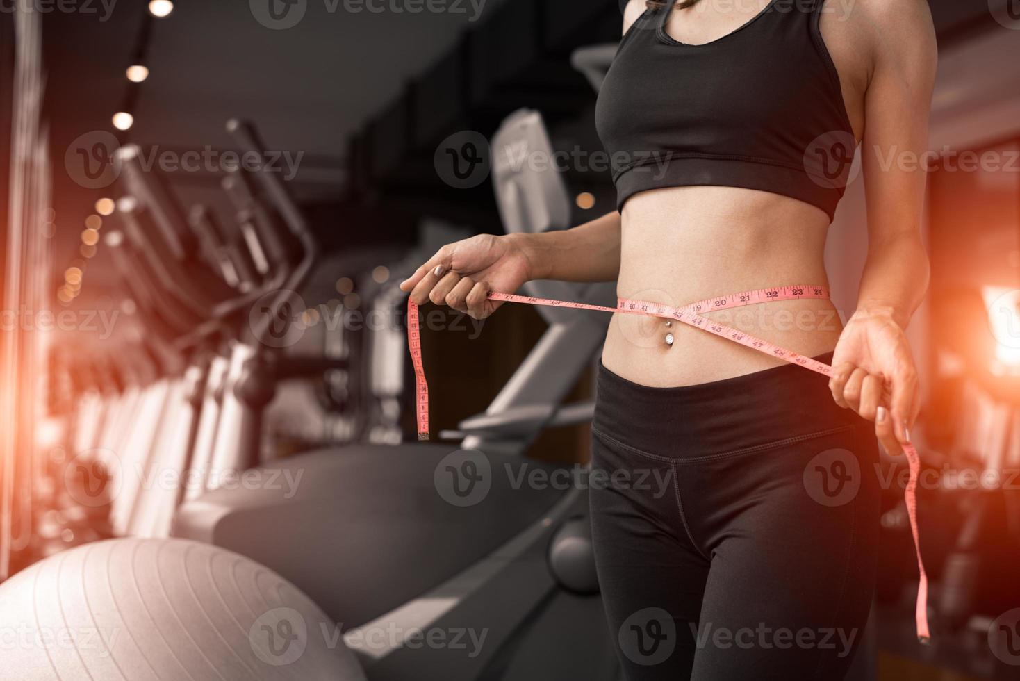Mujer deportiva con línea de cinta de cintura en el gimnasio de entrenamiento del club deportivo foto