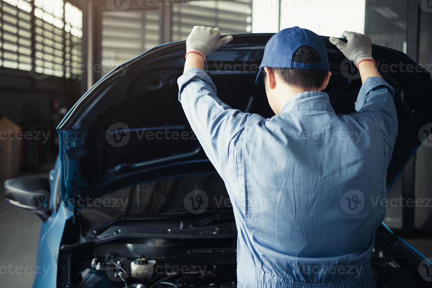 Car mechanic opening car hood for internal checking to maintenance photo