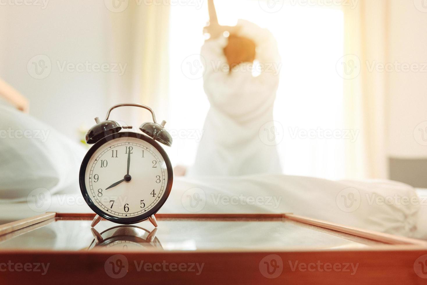 Back view of woman stretching in morning after waking up photo