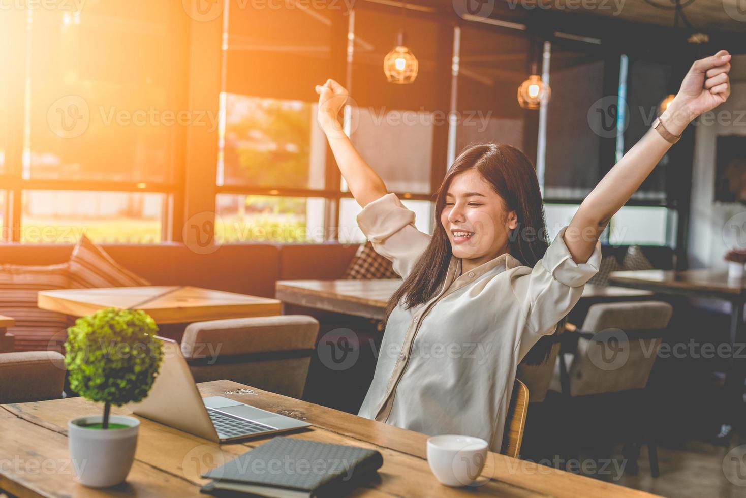 Belleza mujer asiática levantando dos manos después de terminar el trabajo foto