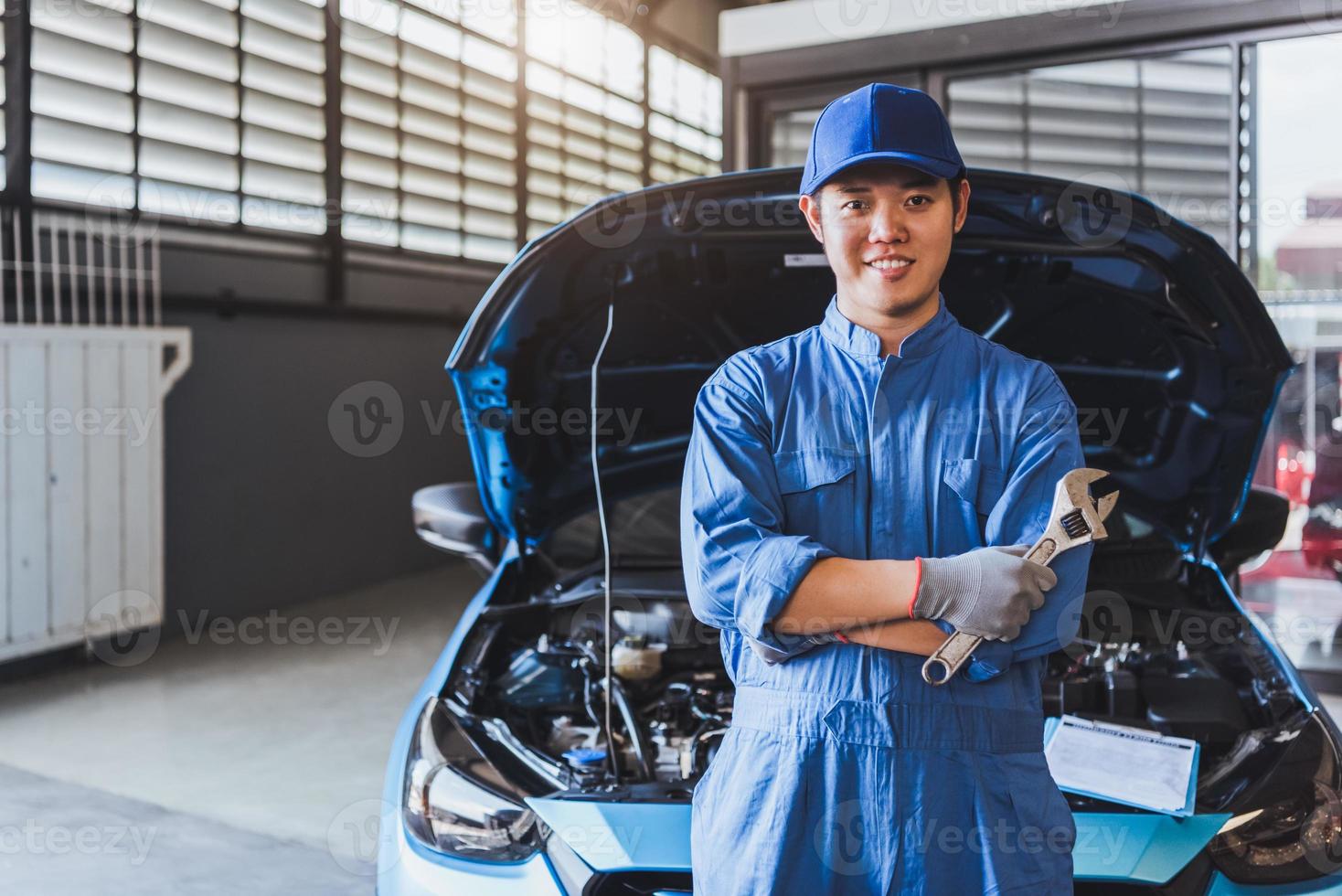 Happy car mechanic inspection technician holding wrench photo