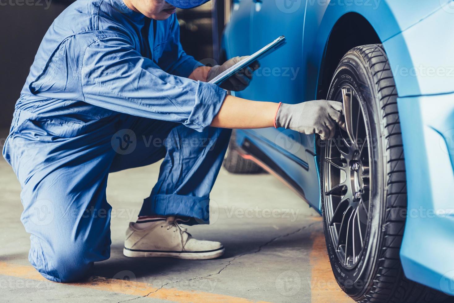 Técnico mecánico de automóviles asiáticos sosteniendo el portapapeles comprobando el mantenimiento foto