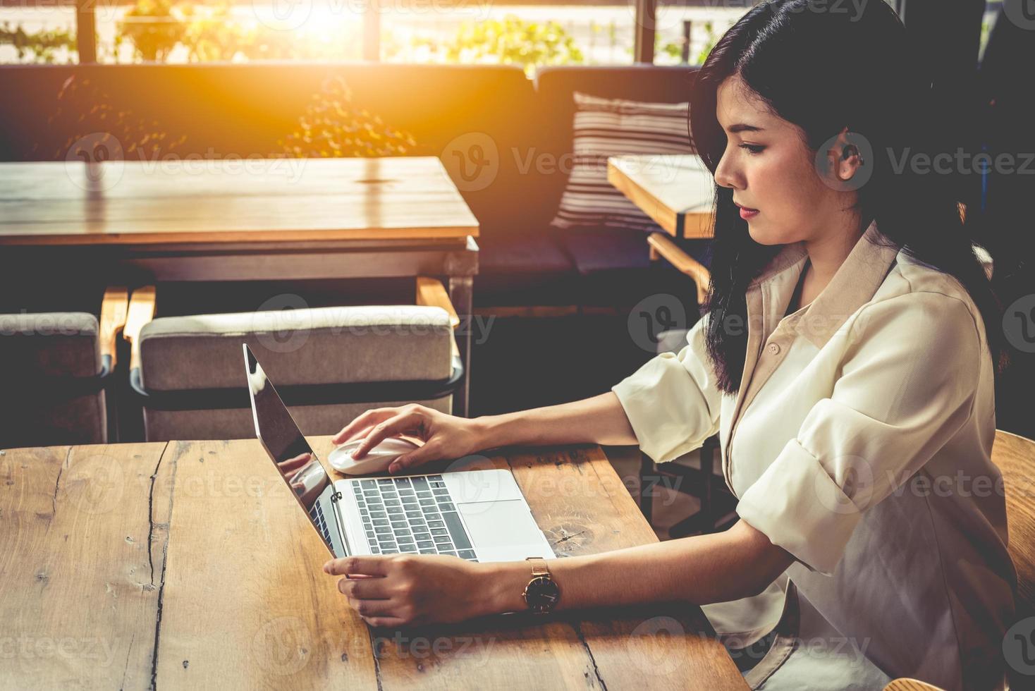 mujer asiática, trabajando, con, computador portatil, en, cafetería foto