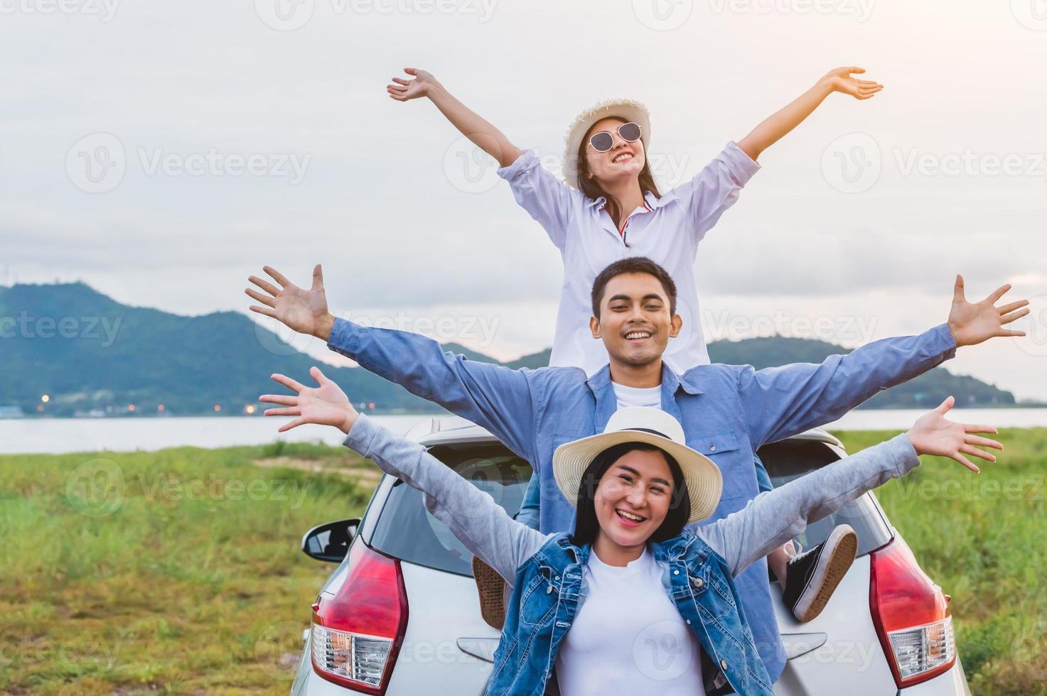 amigos asiáticos felices extendieron los brazos ampliamente y respiraron aire fresco foto