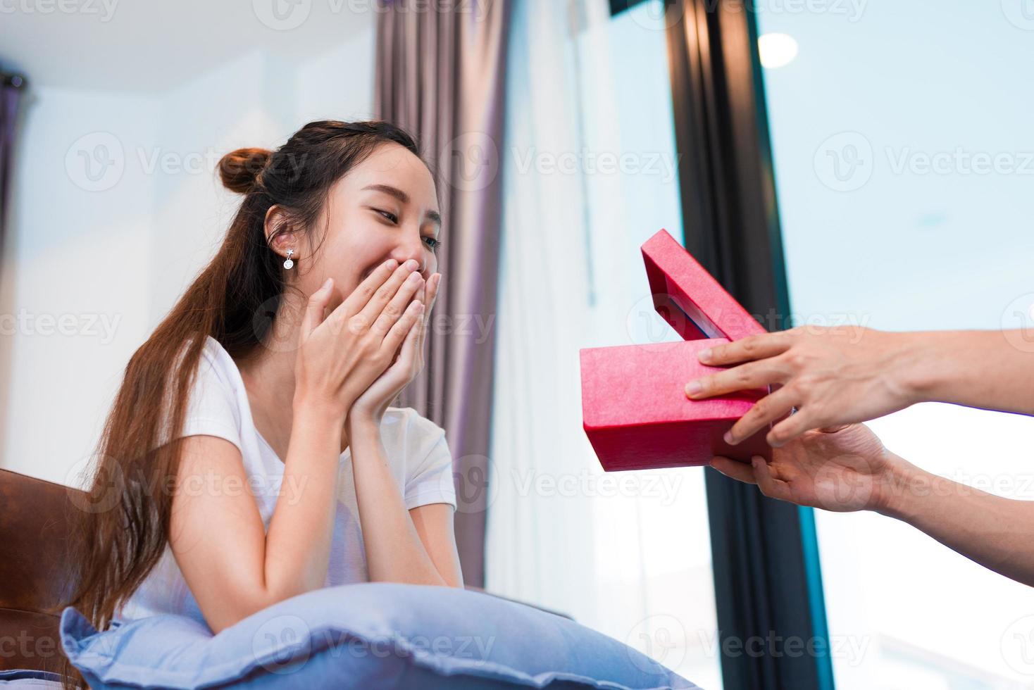 mujer sorprendida al mirar la caja de regalo en un día especial foto