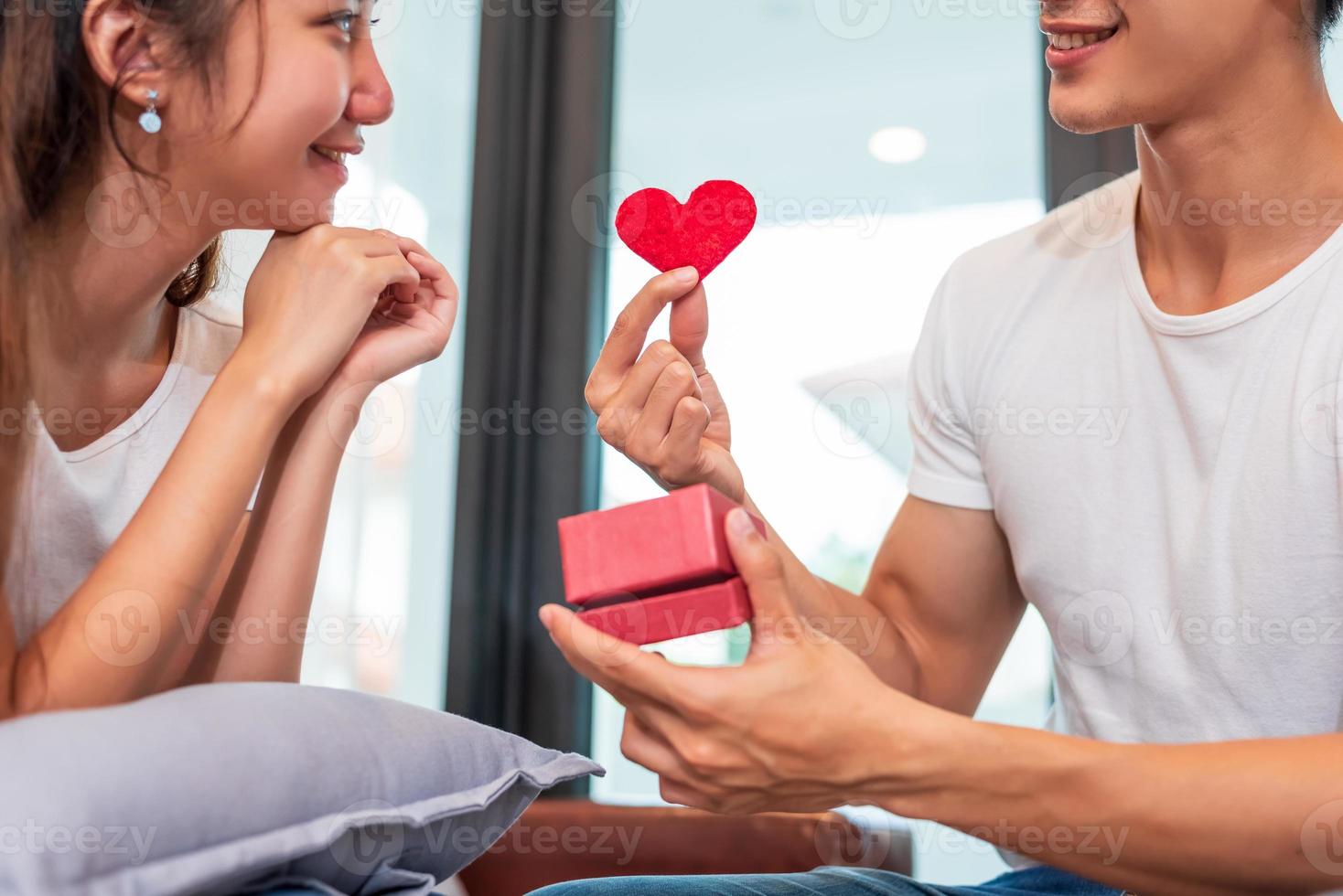 Hombre sujetando caja de regalo para novia sorpresa en su casa foto