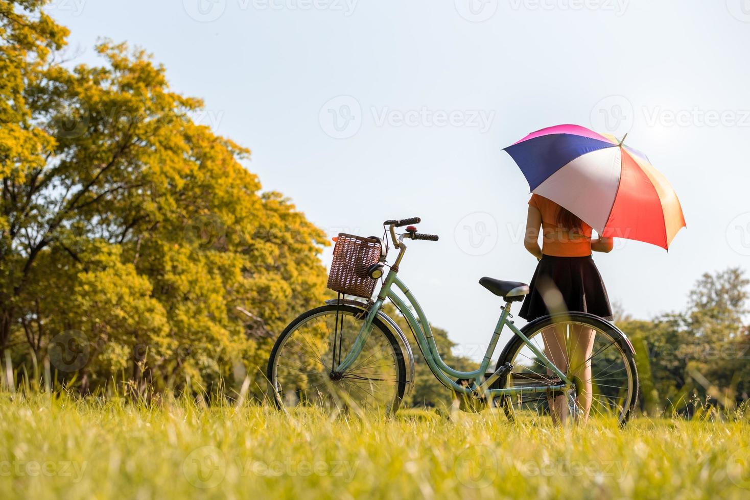 mujer, con, colrful, paraguas, y, bicicleta, en el estacionamiento foto