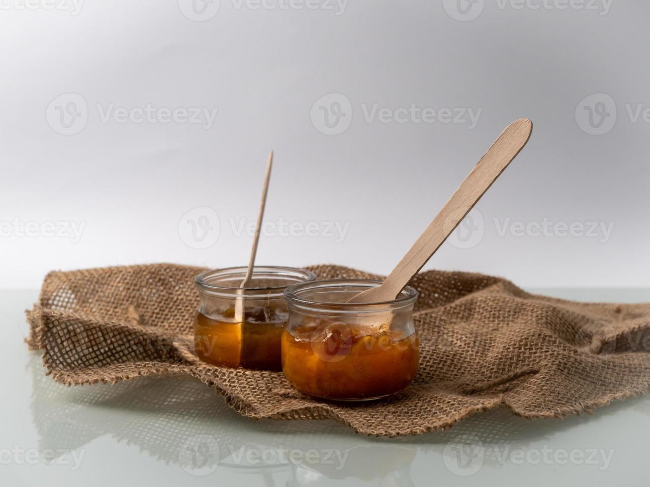 jam in a glass jar with wooden spoon inside, ecological food concept photo