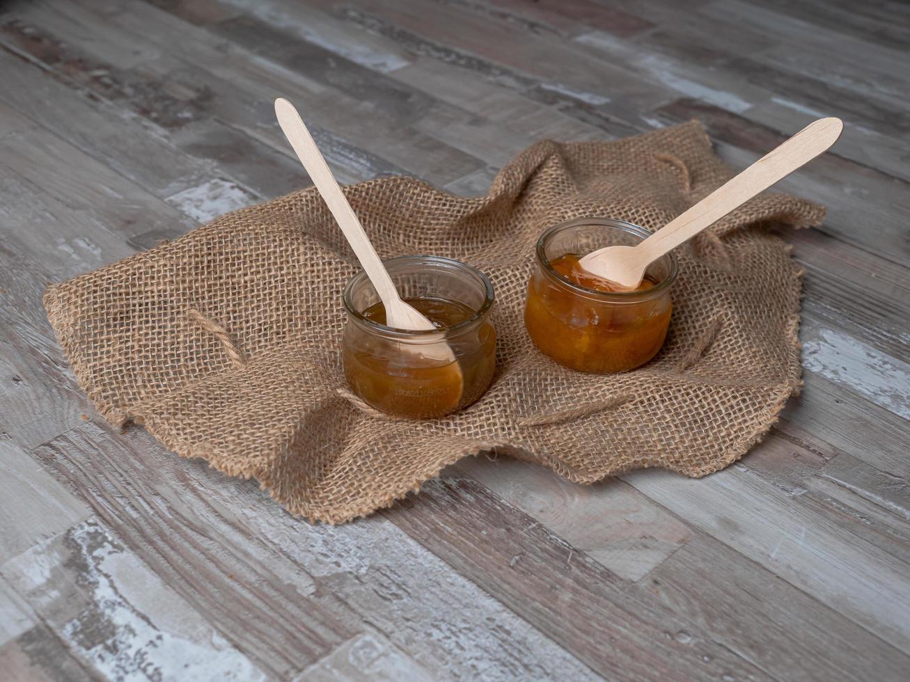 jam in a glass jar with wooden spoon inside, ecological food concept photo