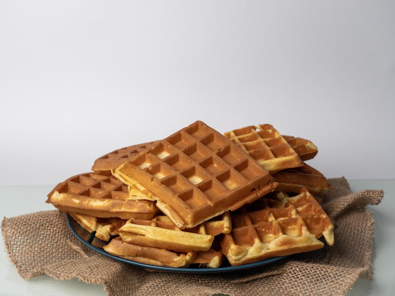 Belgian waffles on top of each other and on a plate. photo