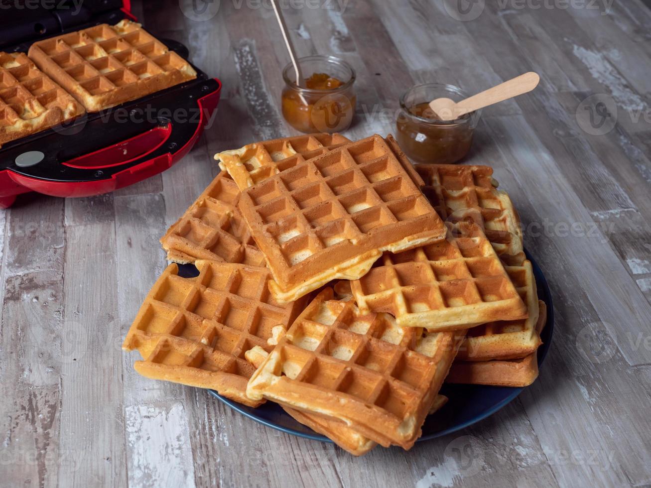 Belgian waffles stacked on top of each other and on a plate photo