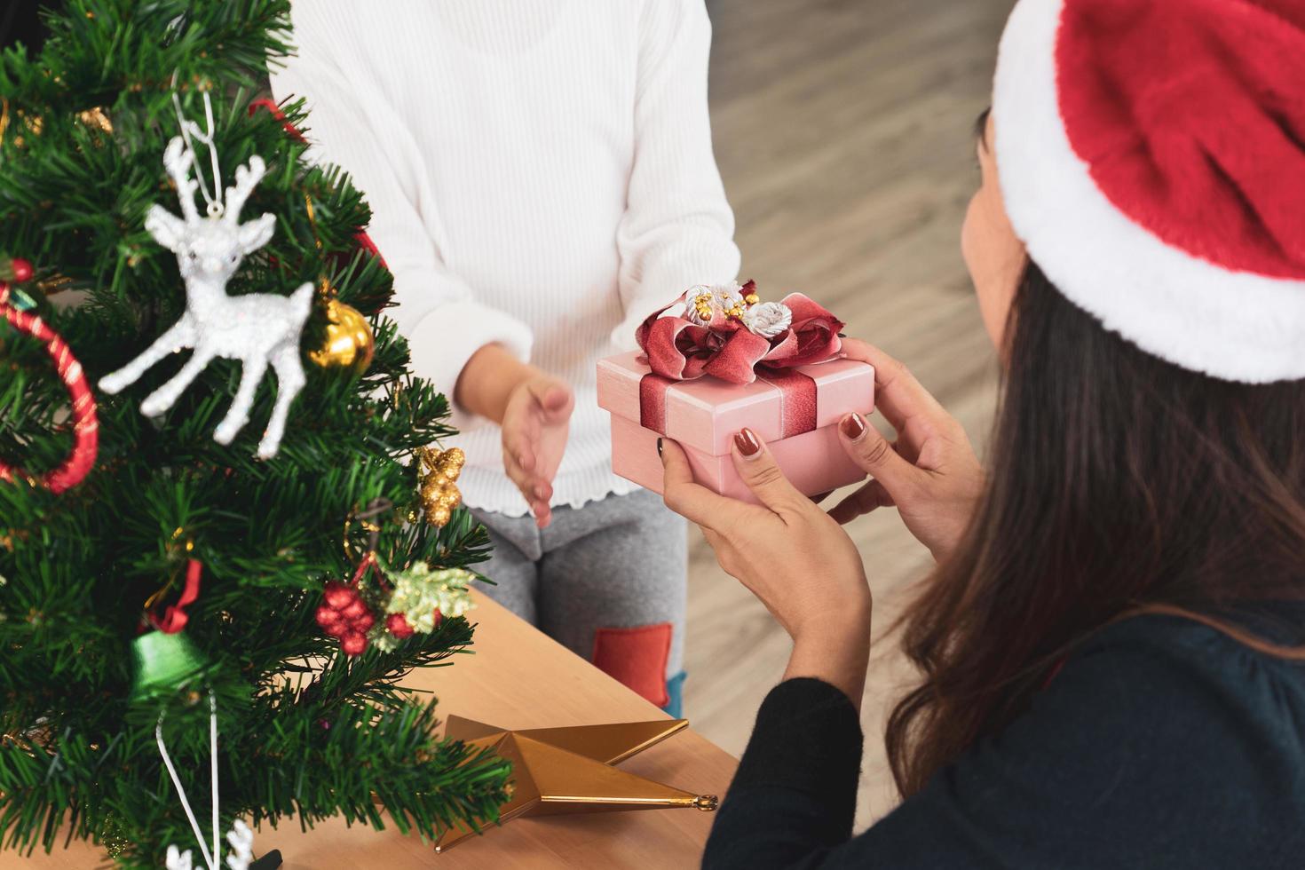 Mother gives presents to her young daughter in christmas holiday photo