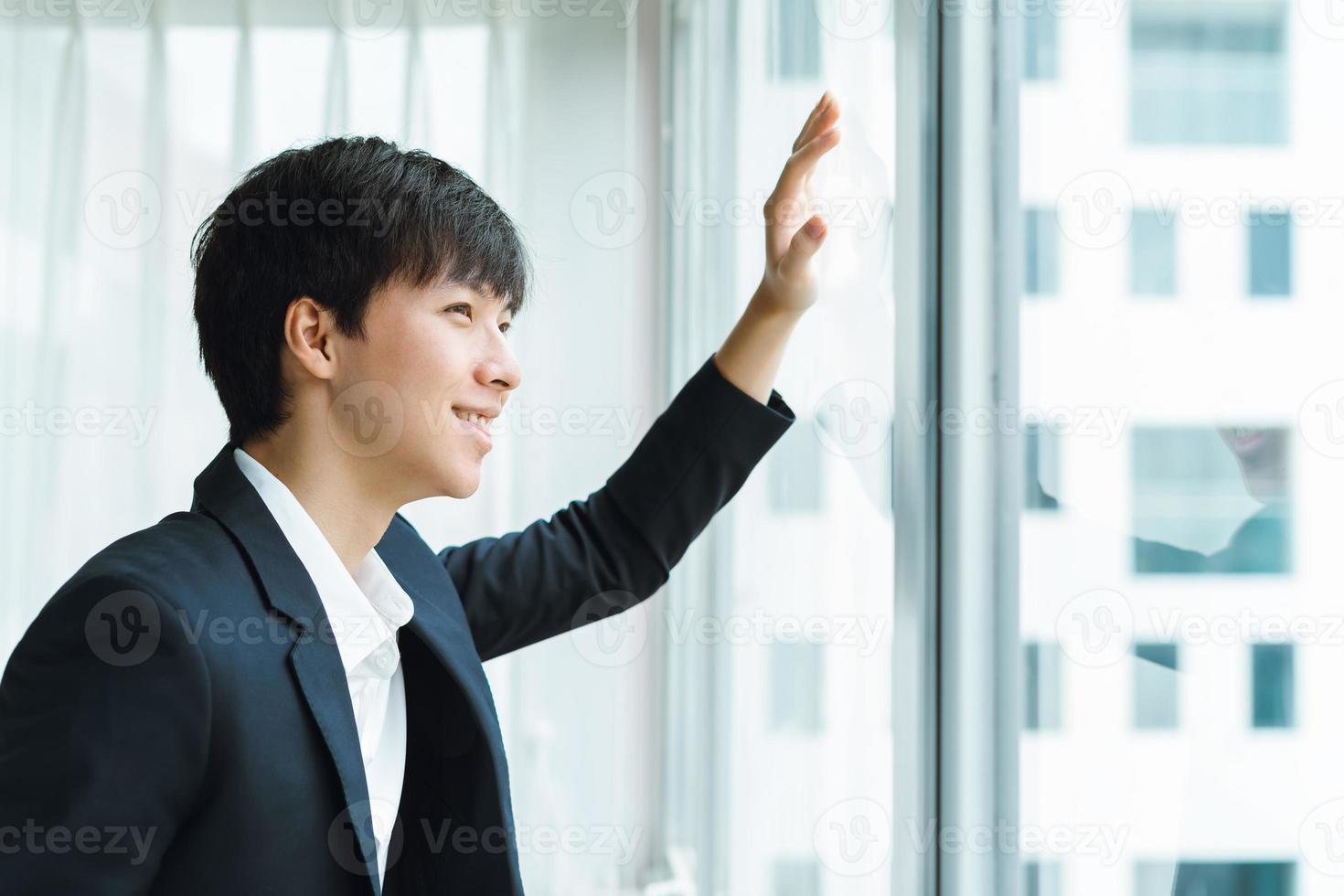 A man in a business suit looks out the window photo