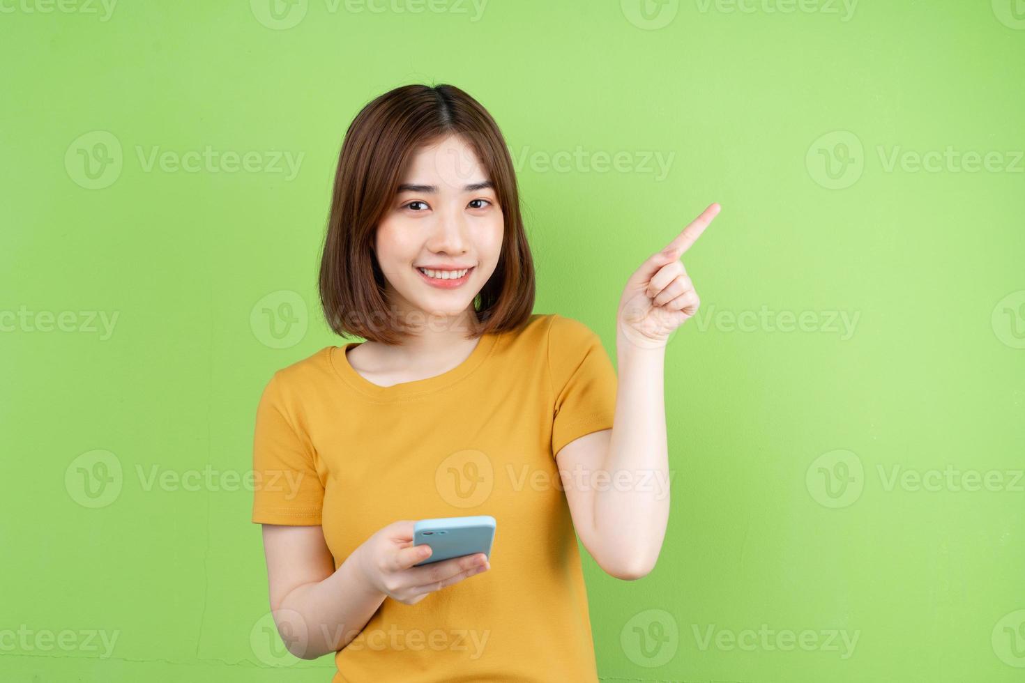 joven asiática posando sobre fondo verde foto
