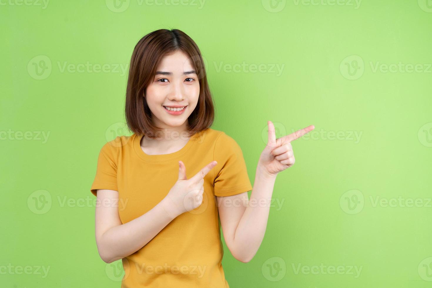 joven asiática posando sobre fondo verde foto