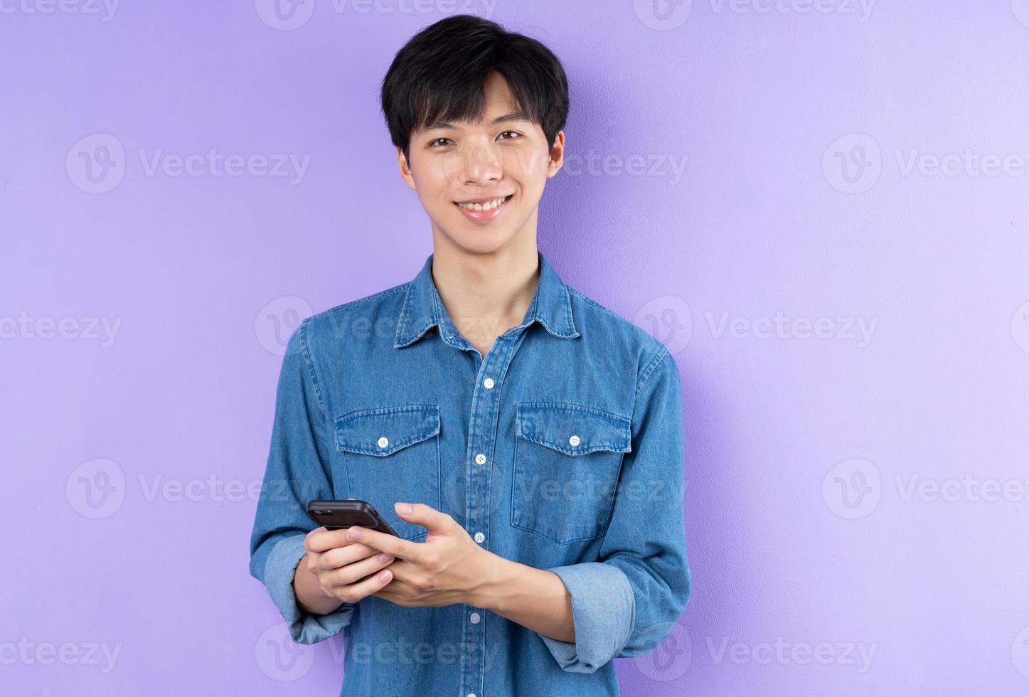 retrato, de, hombre asiático, en, camisa azul, posar, en, fondo púrpura foto