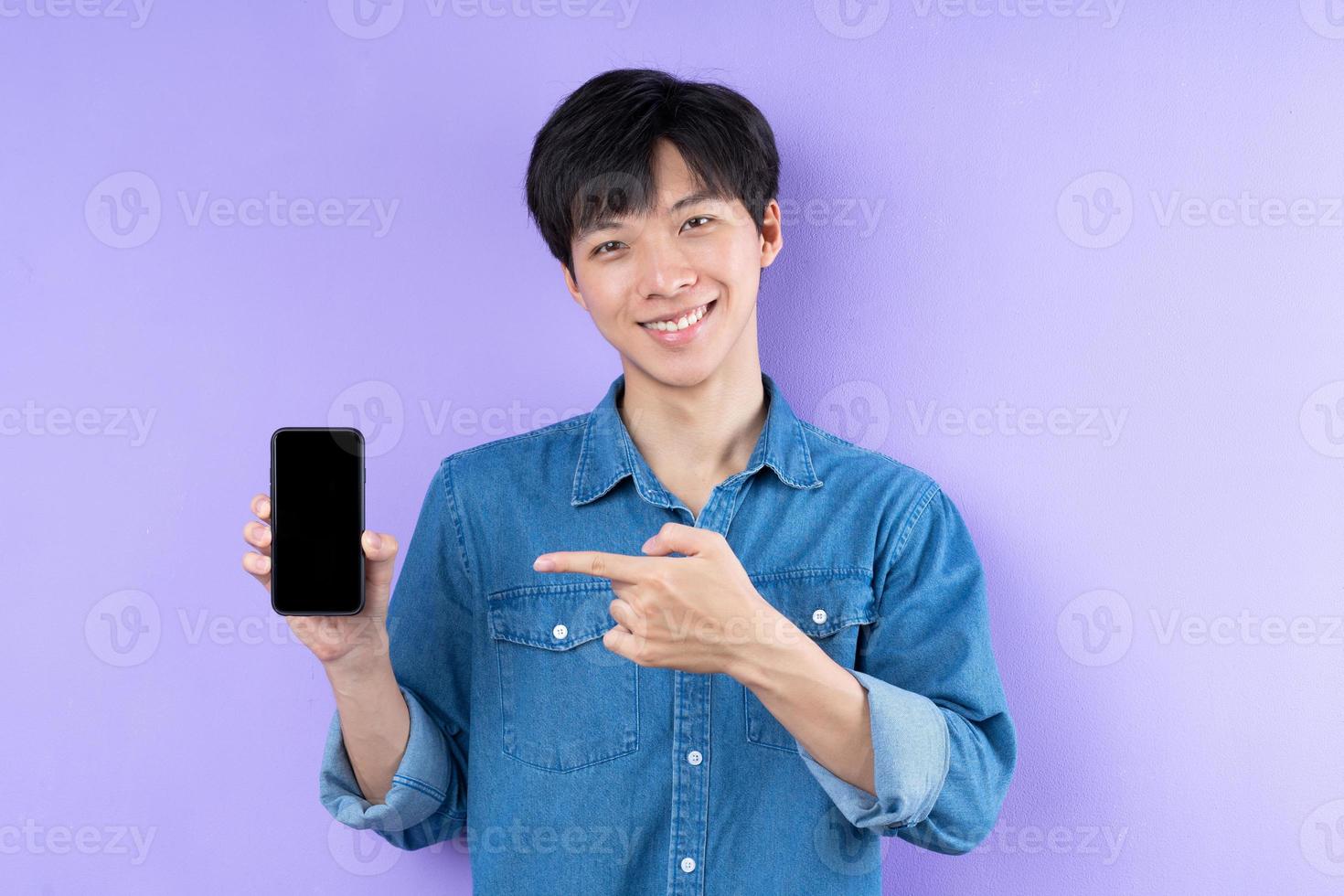 retrato, de, hombre asiático, en, camisa azul, posar, en, fondo púrpura foto