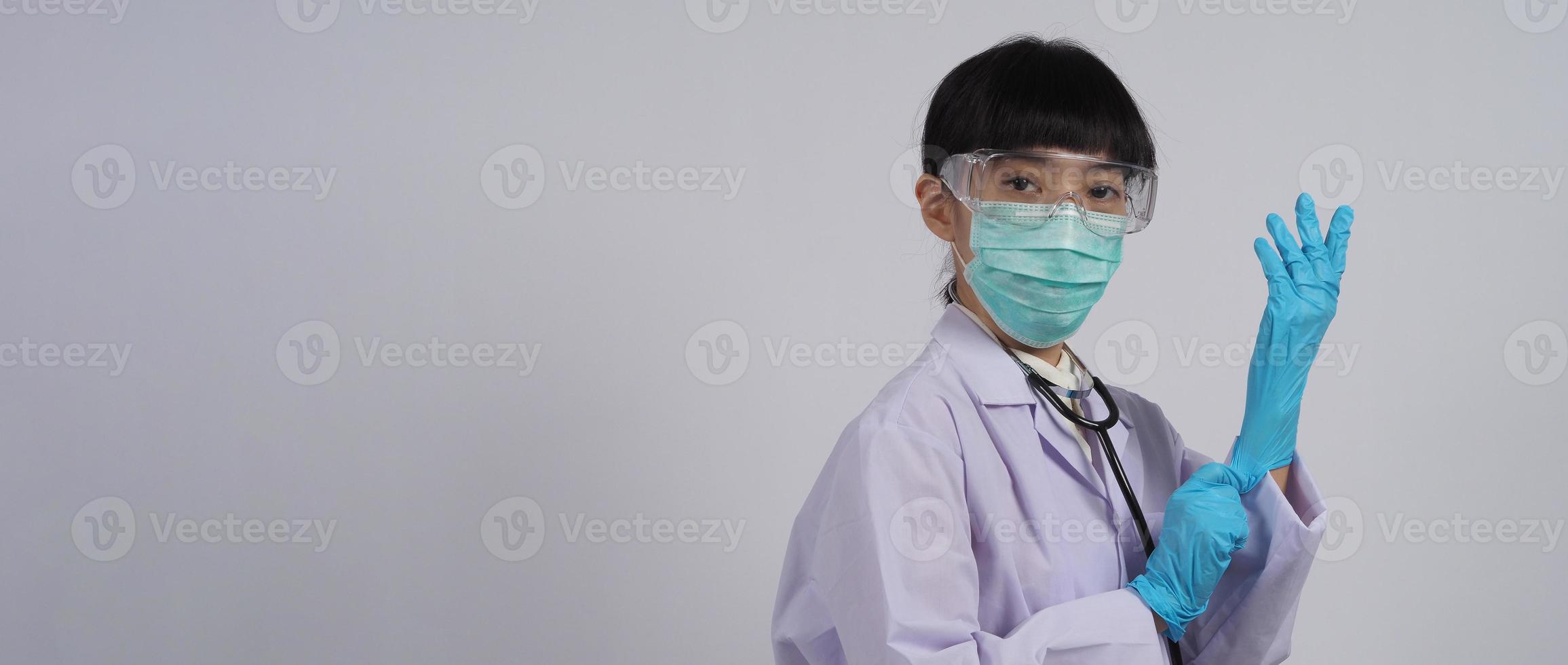 usando guantes. El médico asiático usa guantes de manos de nitrilo de goma azul. foto