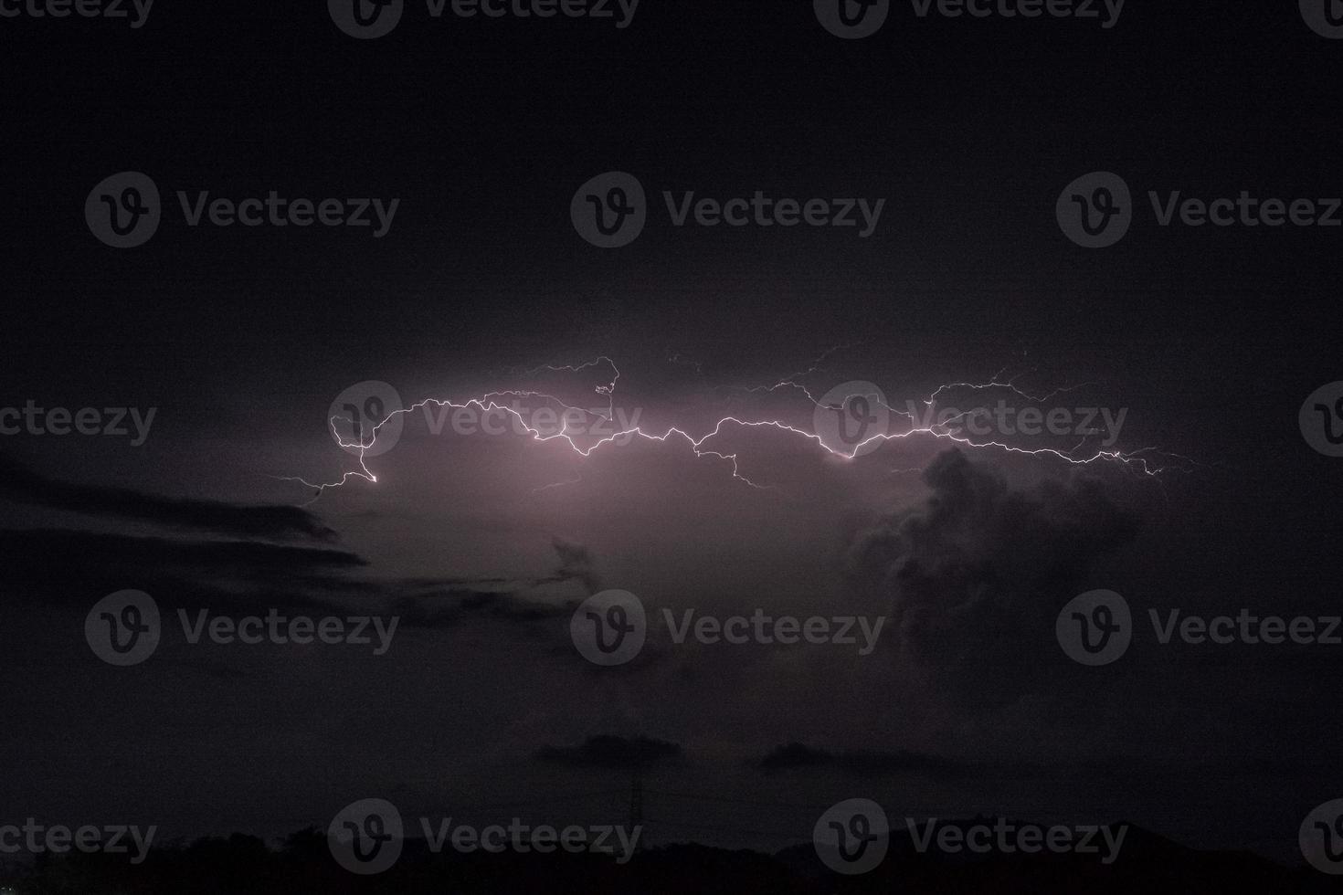 un rayo golpea en la noche oscura con la nube de lluvia foto