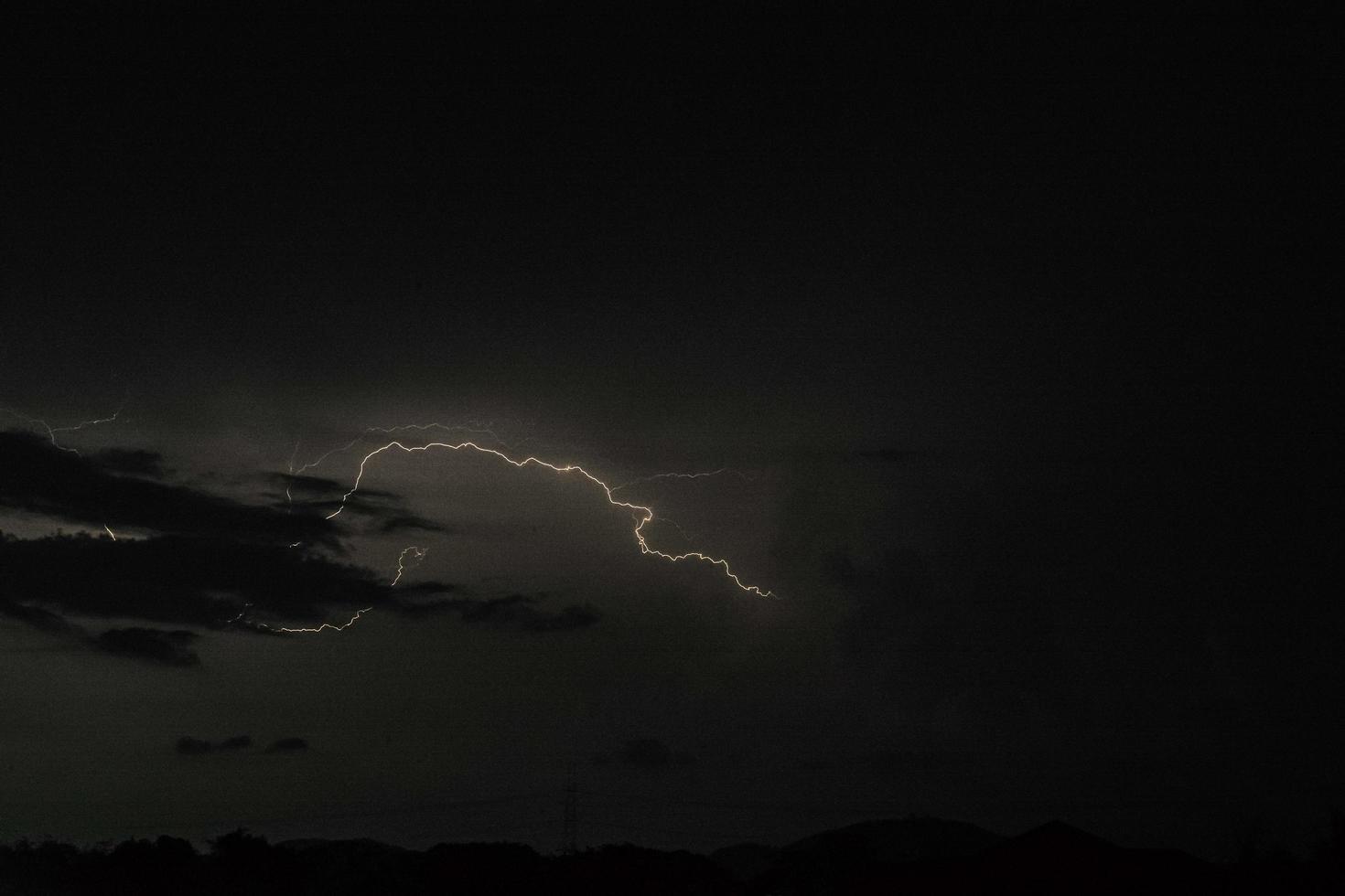 un rayo golpea en la noche oscura con la nube de lluvia foto