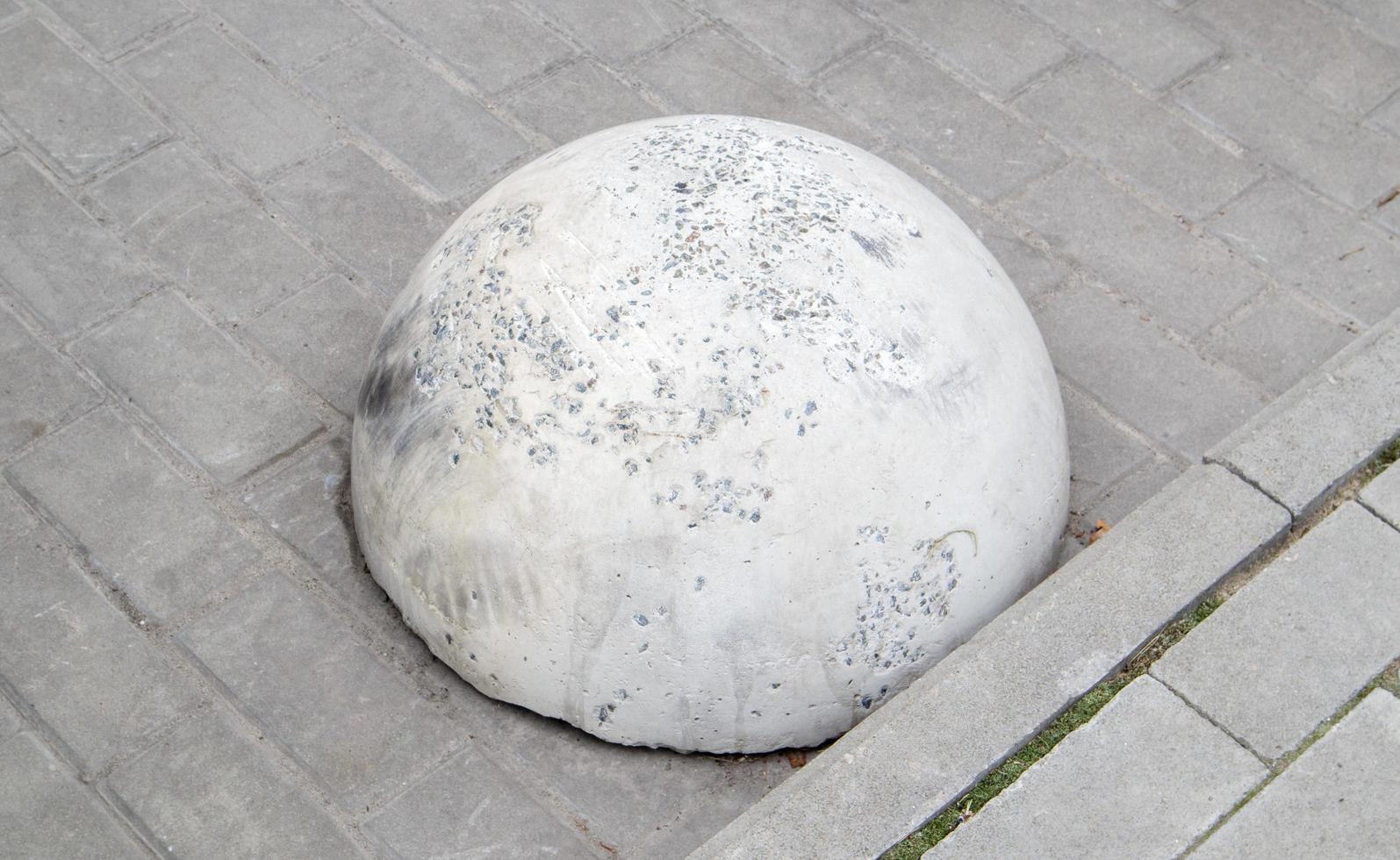 Round concrete road parking block in the shape of a hemisphere photo