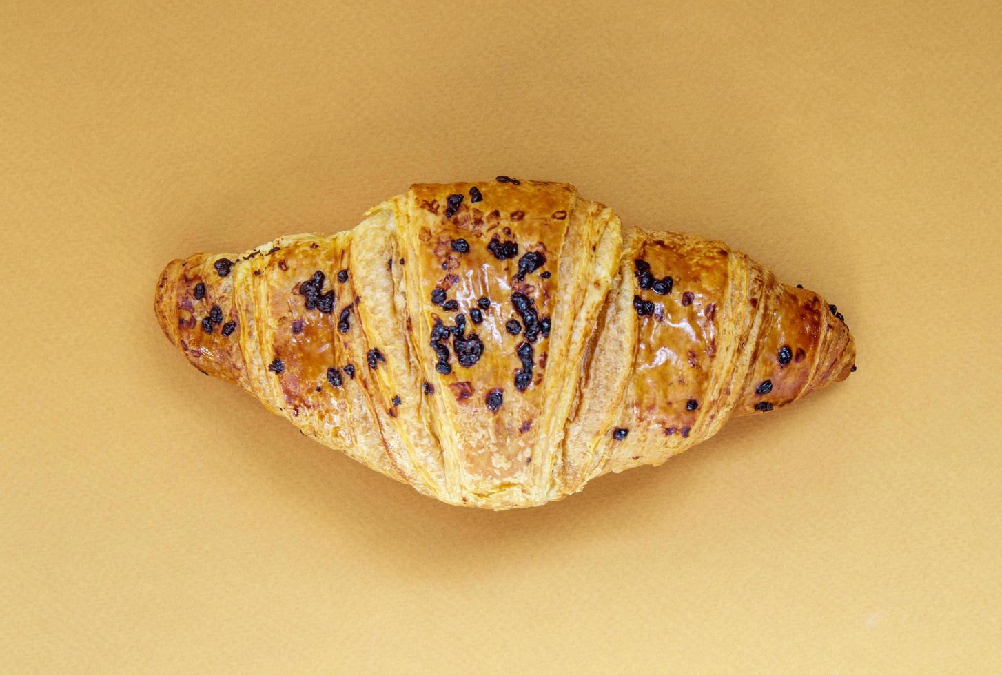 un croissant de grano entero crujiente fresco regular con chocolate. foto