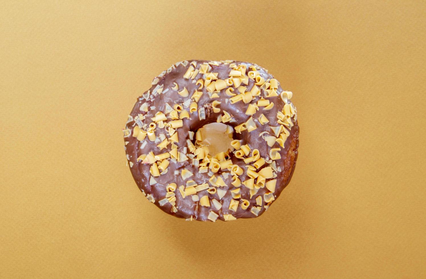 Fresh chocolate donut isolated on coffee background. photo