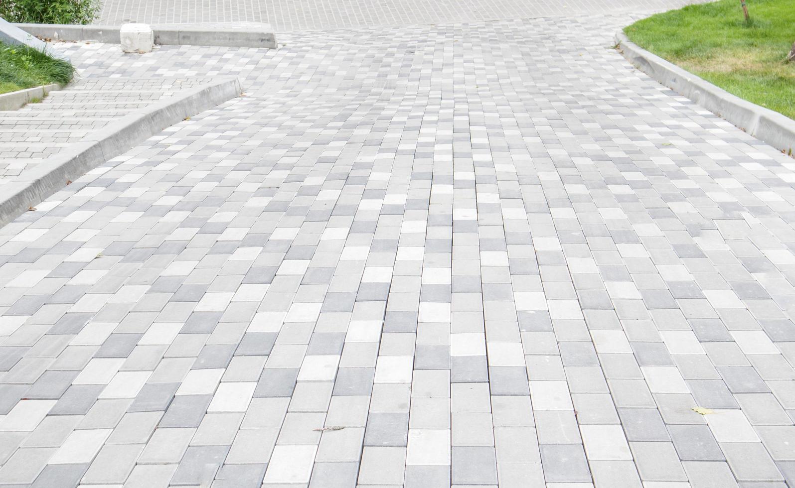 un largo descenso cubierto de adoquines grises. la rampa está pavimentada con foto