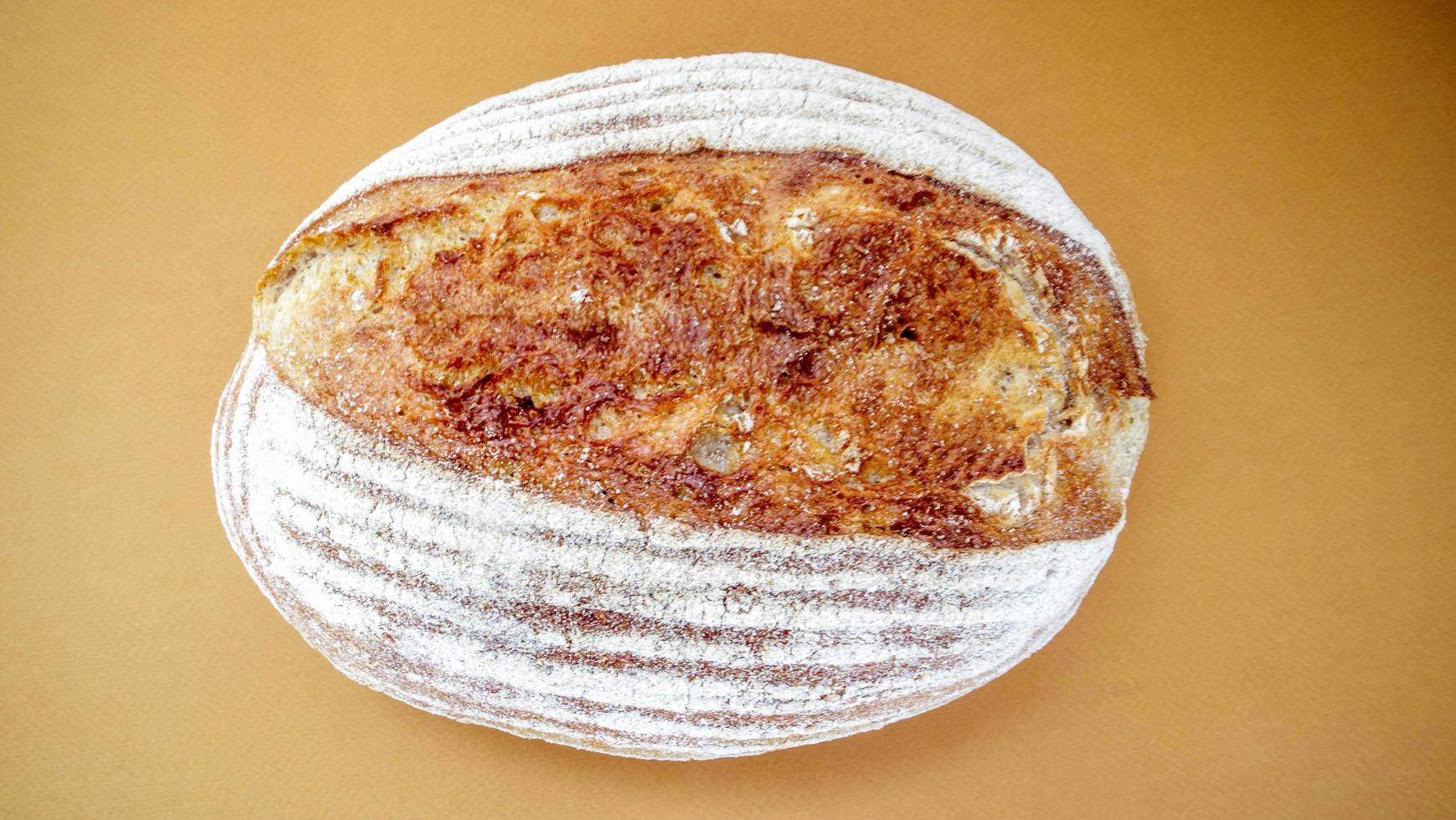 Freshly baked organic sourdough bread isolated on brown or coffee photo