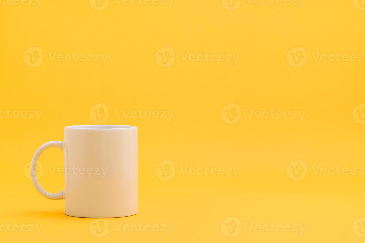 A white coffee mug on a yellow background photo