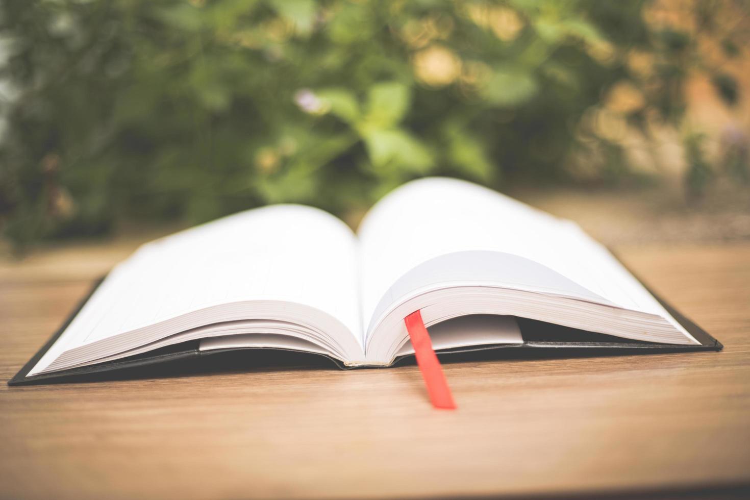 An open book on  wooden table at home garden photo