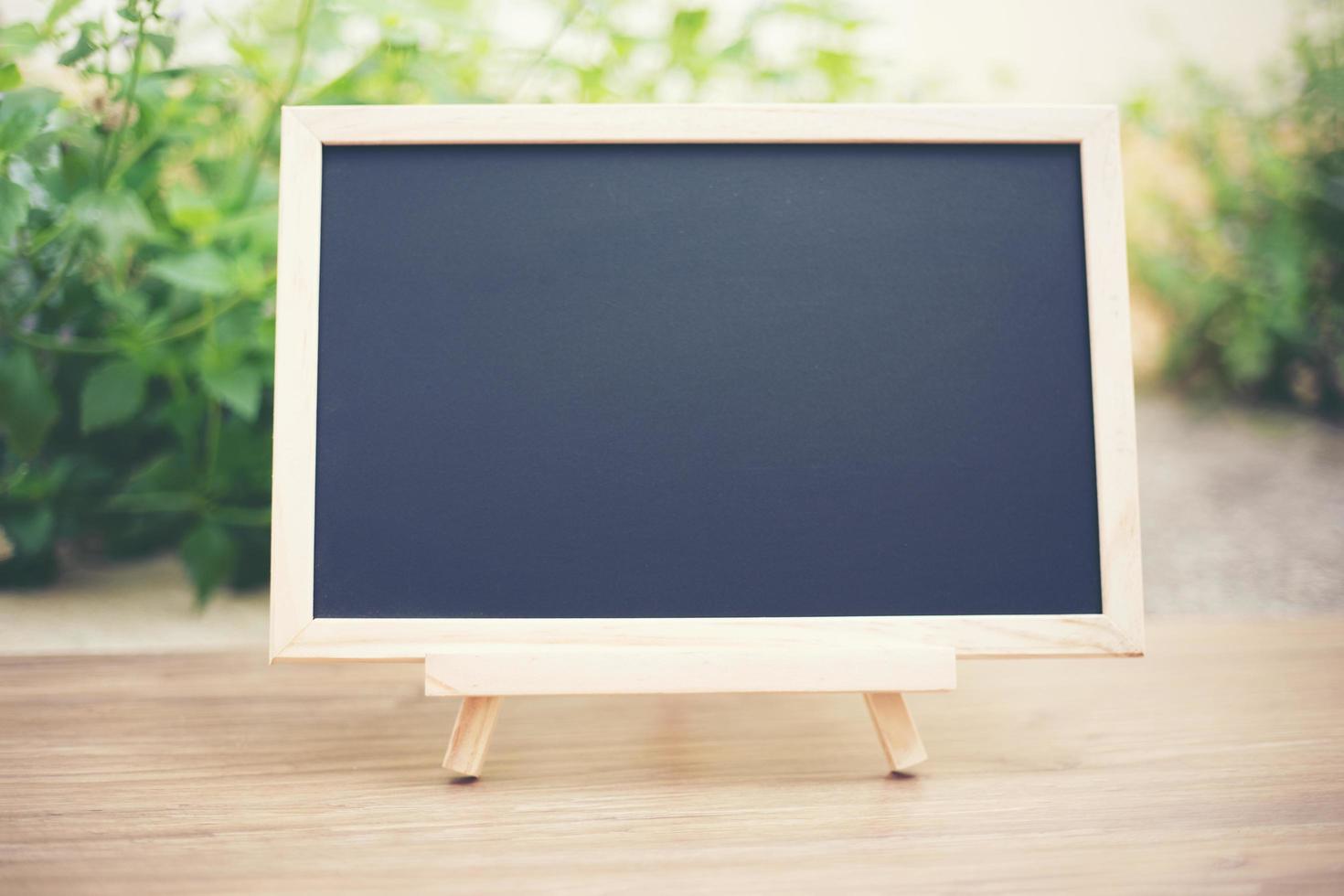 Black board on wood table top Template mock up for display of product photo