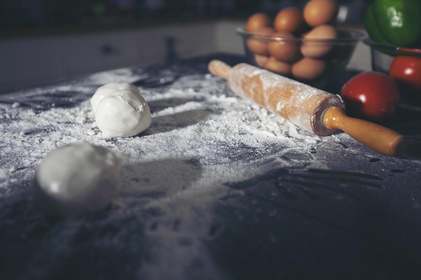 preparando una pizza en la mesa de la cocina foto