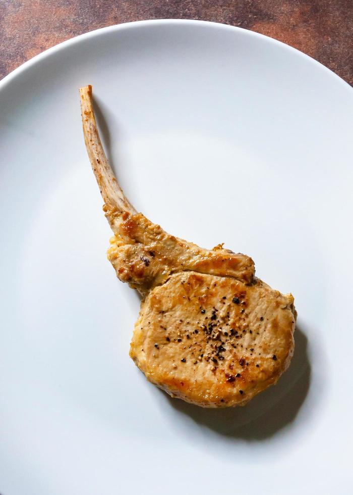 Roasted Pork Chop, Grilled pork loin served in a white dish photo