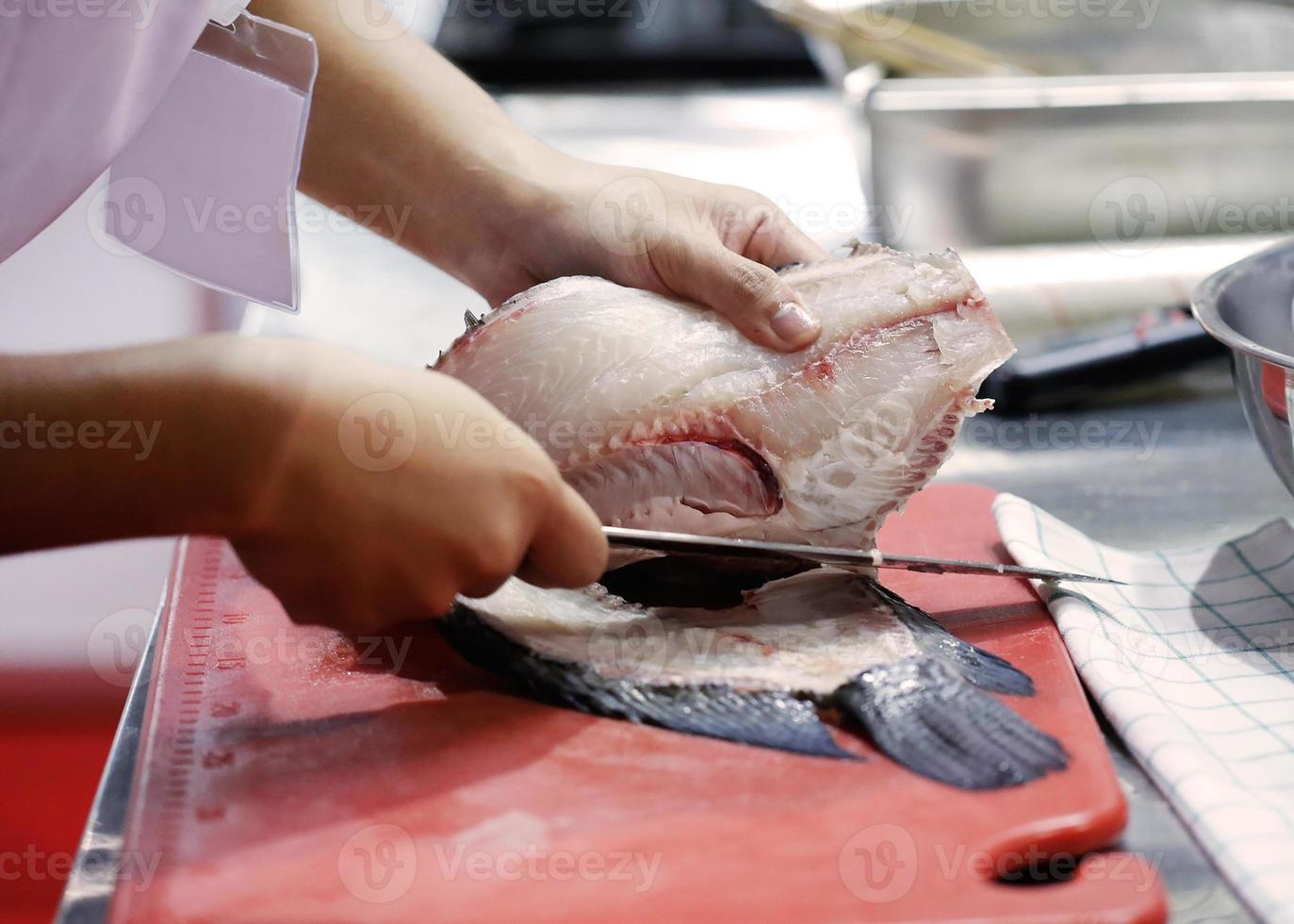 Chef cutting fish, Chef slices fish fresh on Board in the kitchen photo