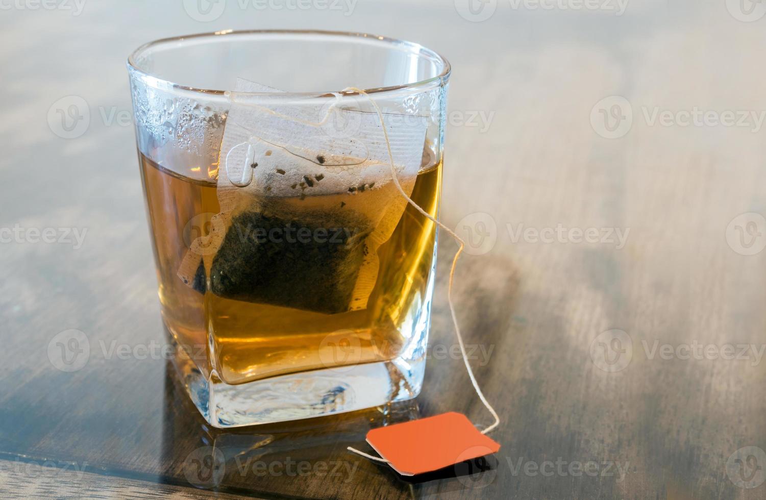 bolsitas de té en vidrio transparente y agua caliente foto